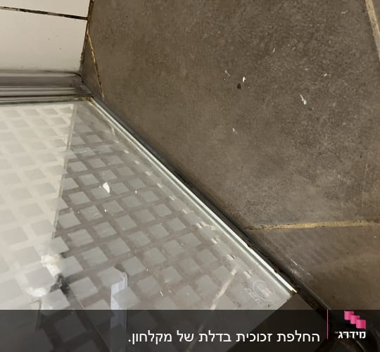 פינת מקלחון עם דלת זכוכית ודוגמת ריבועים